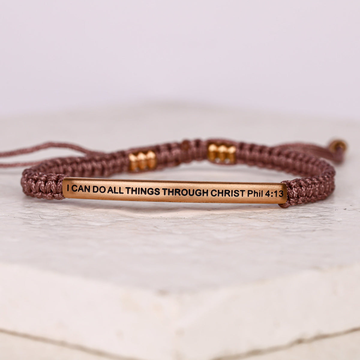 Woven rope bracelet with rose gold metal bar engraved with the Bible verse &