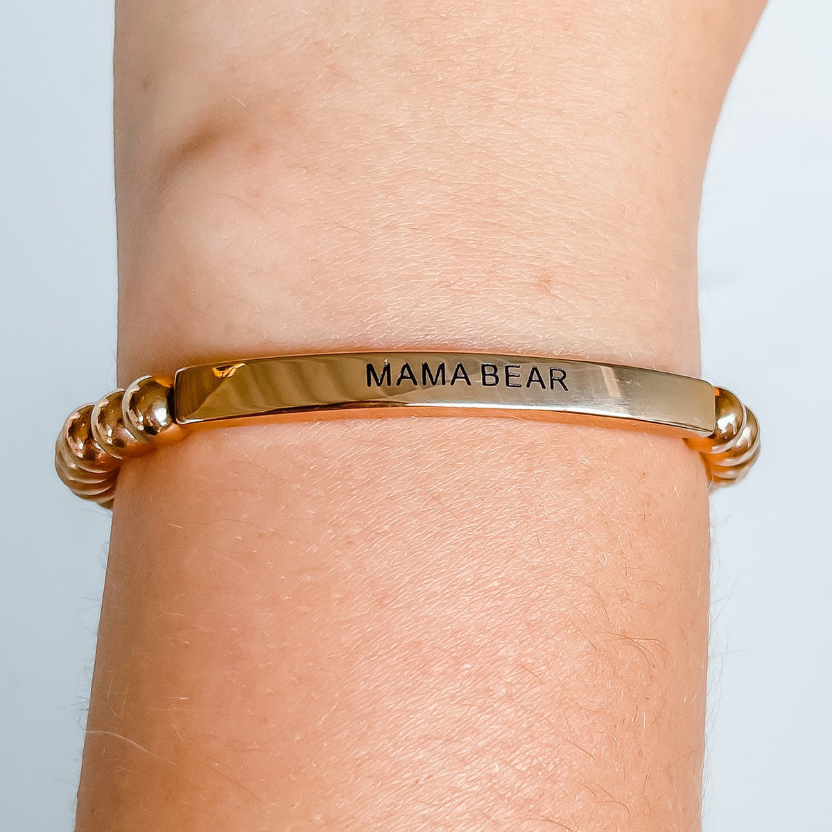 Close-up of MAMA BEAR beaded bracelet showing engraved message bar
