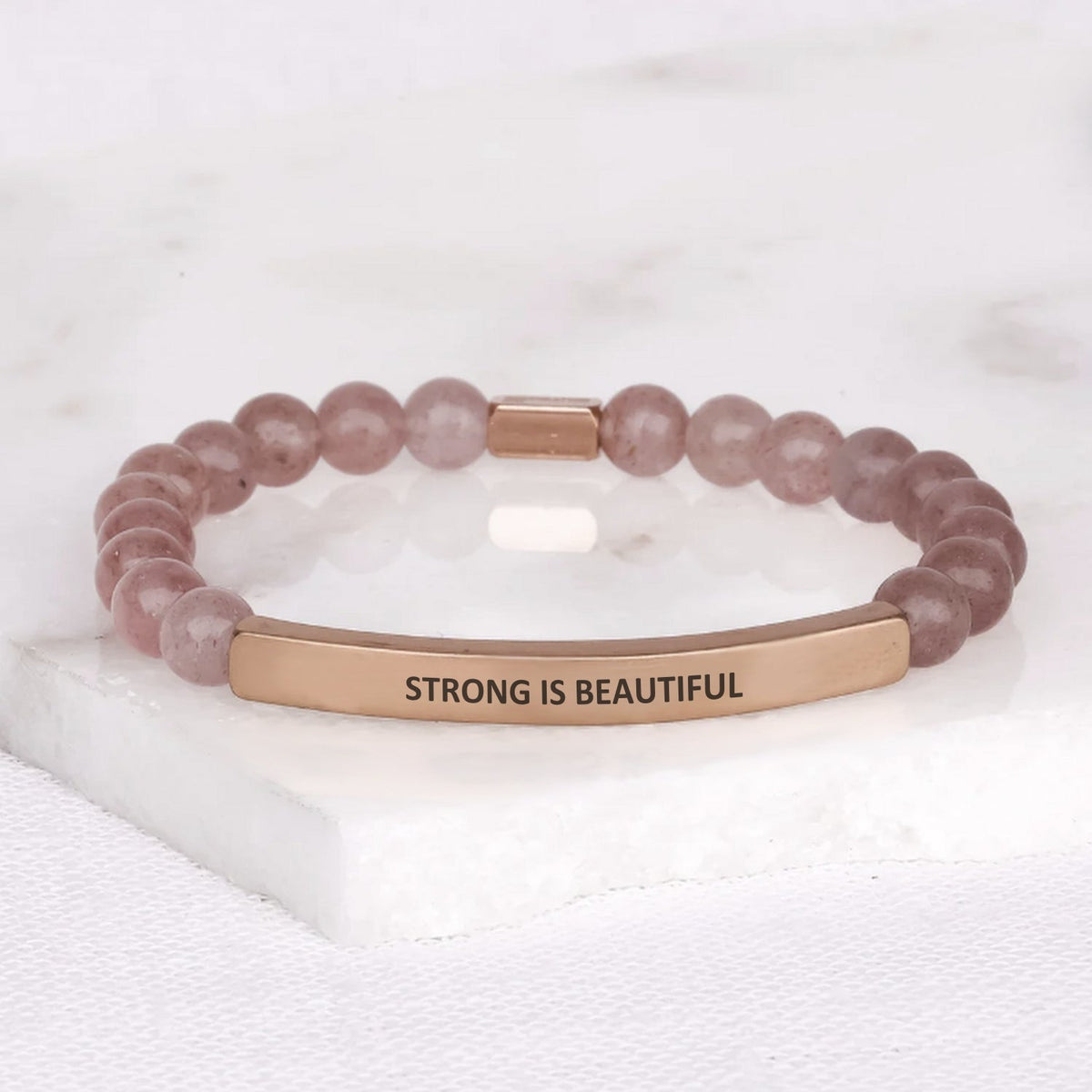 Inspirational gift bracelet for women featuring the words STRONG IS BEAUTIFUL