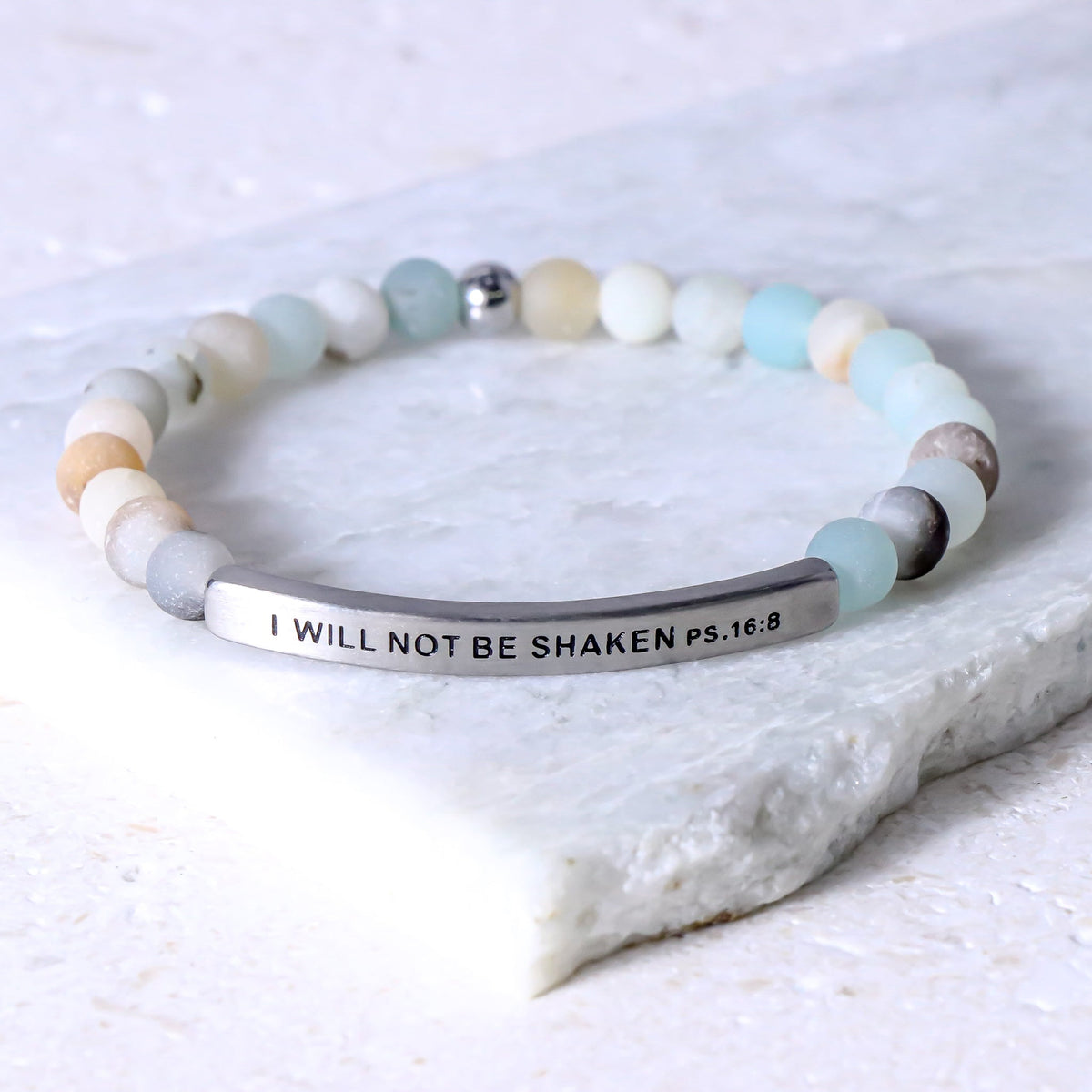 A beaded stretch bracelet with a silver-toned curved bar engraved with the text &