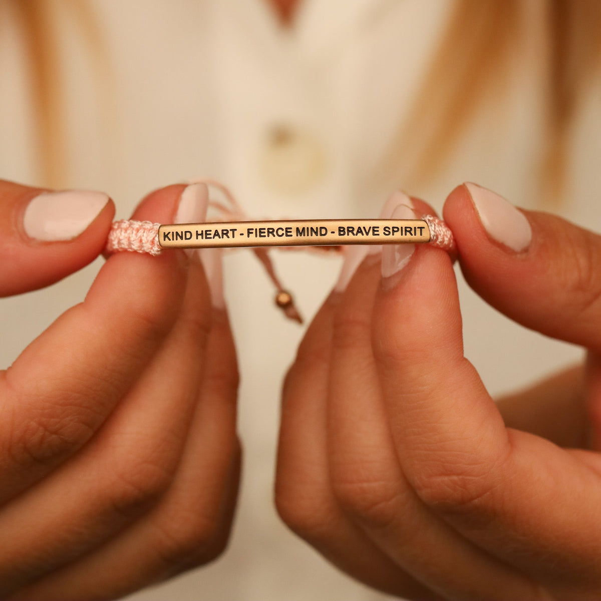 Close-up of rope bracelet featuring Kind Heart Fierce Mind Brave Spirit message