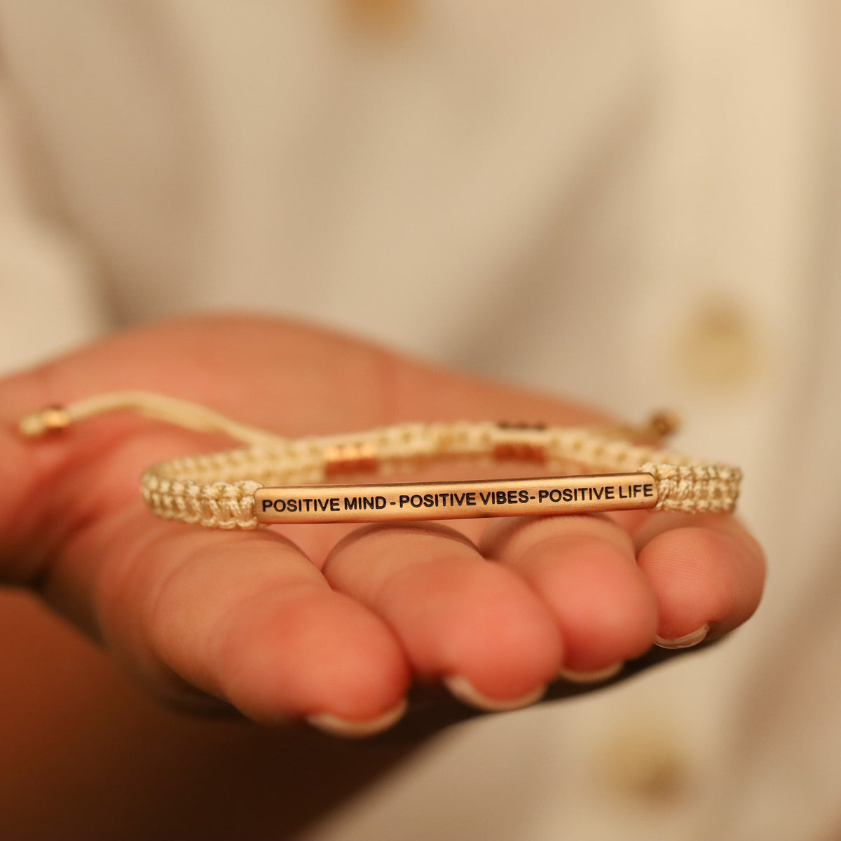 Close-up of Positive Mind Positive Vibes Positive Life rope bracelet showing engraved message