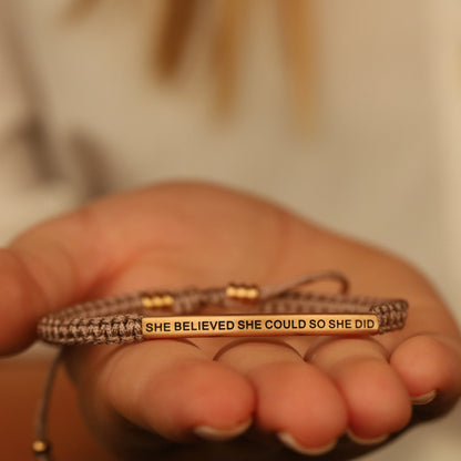 Close-up of She Believed She Could So She Did rope bracelet showing engraved message